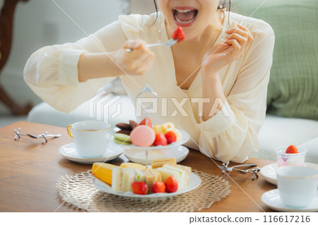 A woman eating sweets at a cafe A woman eating sweets at a cafe 116617216