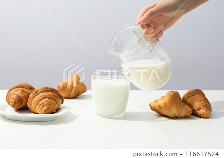 A glass of milk with croissants on the table 116617524