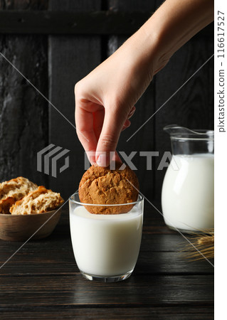 A glass of milk with cookies on a dark background A glass of milk with cookies on a dark background 116617527