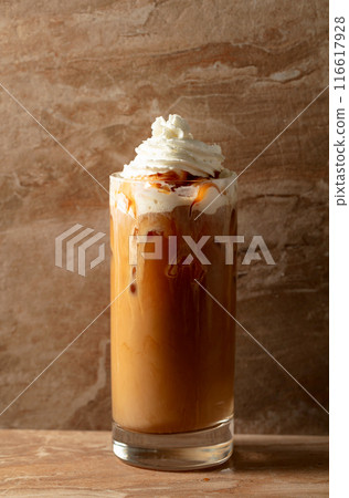 Iced caramel latte topped with whipped cream and caramel sauce. Iced caramel latte topped with whipped cream and caramel sauce. 116617928