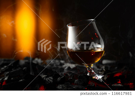 Snifter of brandy on a burning charcoal. Snifter of brandy on a burning charcoal. 116617981