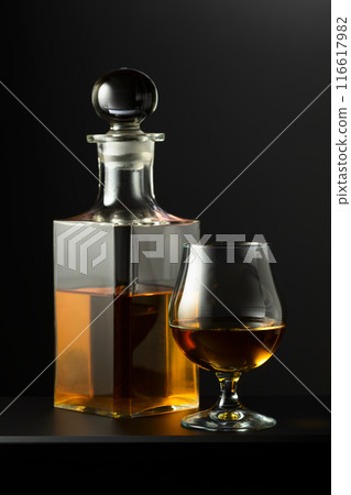 Old decanter and glass with whiskey, cognac or brandy. Old decanter and glass with whiskey, cognac or brandy. 116617982