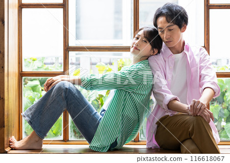 Young couple relaxing by the window Young couple relaxing by the window 116618067