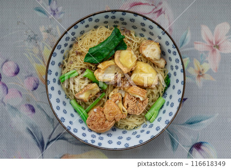 Top view of Egg Noodles with Fried tofu and Chinese kale without Soup sprinkled with Fried garlic. Top view of Egg Noodles with Fried tofu and Chinese kale without Soup sprinkled with Fried garlic. 116618349