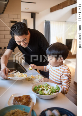 Father and son serving side dishes 116619614
