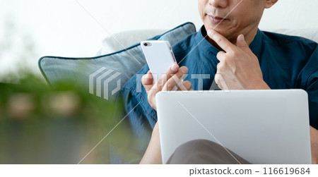 在沙發上使用電腦的男人 116619684