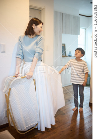 Mother carrying laundry and son wanting attention Mother carrying laundry and son wanting attention 116619862