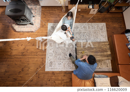 A family enjoying a relaxing time in a living room with a hammock 116620009