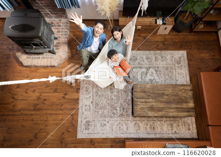 A family enjoying a relaxing time in a living room with a hammock A family enjoying a relaxing time in a living room with a hammock 116620028