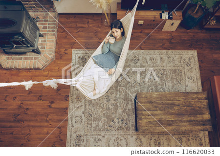 Woman relaxing in a hammock 116620033