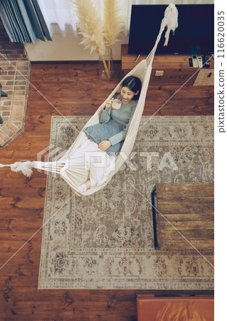Woman relaxing in a hammock 116620035