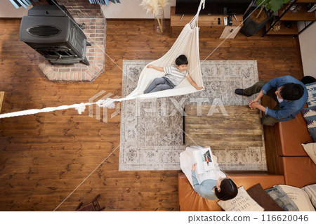 A family enjoying a relaxing time in a living room with a hammock 116620046
