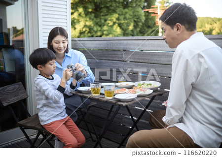 Boy using a camera and parents watching Boy using a camera and parents watching 116620220