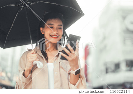 Youth asian woman using smartphone and umbrella at outdoor Youth asian woman using smartphone and umbrella at outdoor 116622114