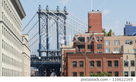 New York City Manhattan Bridge view from Brooklyn Bridge. Red brick residential building windows. 116622169