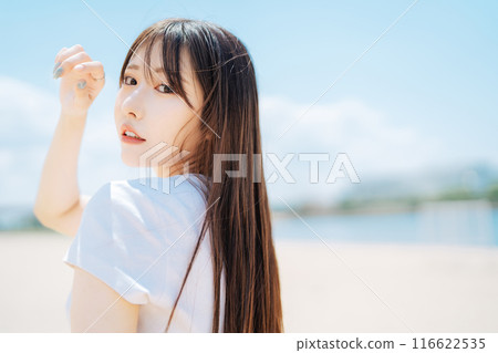Young girl with long hair on blue sky background Young girl with long hair on blue sky background 116622535