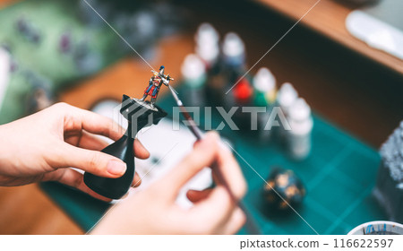 Hand using brush paint acrylic colour to miniatures for tabletop role playing game or board games Hand using brush paint acrylic colour to miniatures for tabletop role playing game or board games 116622597
