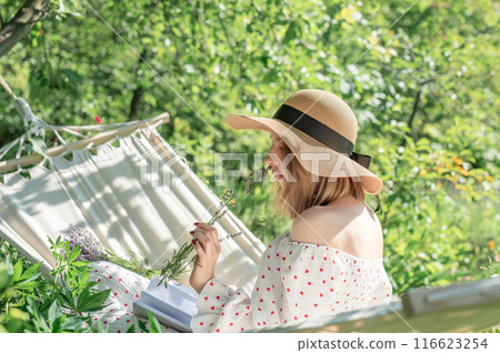 Young woman relaxing in a hammock outdoors 116623254