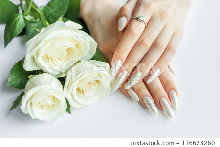 Female Hands on a white background with beautiful pearl manicure Female Hands on a white background with beautiful pearl manicure 116623260