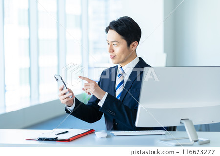A businessman with a smartphone in the office A businessman with a smartphone in the office 116623277