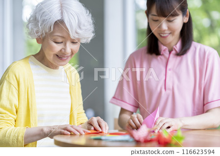 一位資深女性和職能治療師做摺紙的圖片 116623594