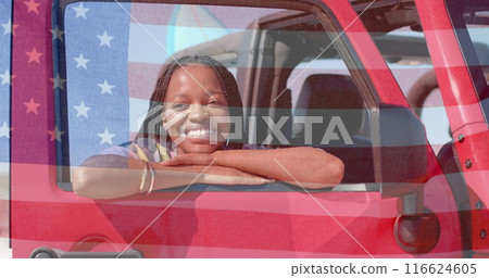 Image of flag of usa over happy african american woman in car by beach Image of flag of usa over happy african american woman in car by beach 116624605