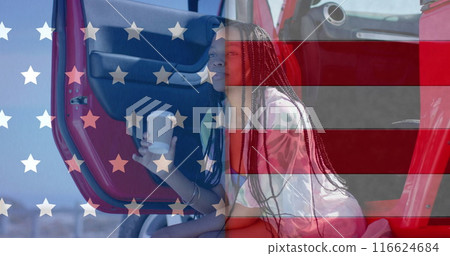 Image of flag of usa over happy african american woman in car drinking coffee in car by beach 116624684
