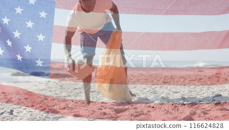 Image of flag of usa over african american man recycling on beach in summer Image of flag of usa over african american man recycling on beach in summer 116624828