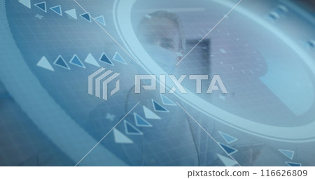 A caucasian female doctor wearing a face mask uses a tablet in a hospital corridor 116626809