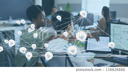 Image of network of bulb icons over two african american female colleagues discussing at office 116626888