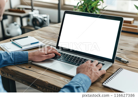 Man using laptop in office sitting at desk. Empty blank white screen mockup. Copy space area for text, logo, app. Person working, male hands typing. Mock up display PC. Business websites, services ads 116627386