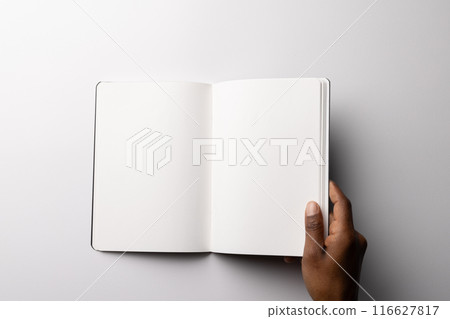 Biracial hand holding an open blank book, with copy space Biracial hand holding an open blank book, with copy space 116627817