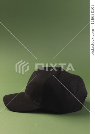 A black baseball cap is displayed against a green background, with copy space A black baseball cap is displayed against a green background, with copy space 116628102