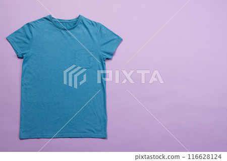 A plain blue t-shirt is laid out on a purple background, with copy space A plain blue t-shirt is laid out on a purple background, with copy space 116628124