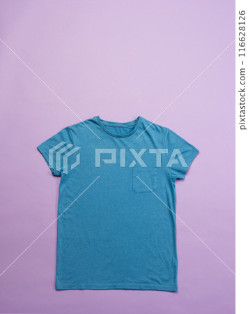 A blue t-shirt is laid out flat against a pink background, with copy space A blue t-shirt is laid out flat against a pink background, with copy space 116628126