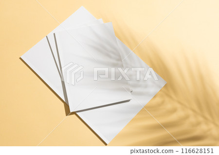 A stack of blank white paper on a yellow background with copy space A stack of blank white paper on a yellow background with copy space 116628151