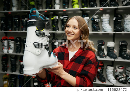 Portrait of woman holding ski shoes while shopping at sports store Portrait of woman holding ski shoes while shopping at sports store 116628472