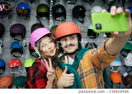 Joyful loving couple taking selfie photo in protective bicycle helmet 116628486