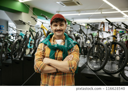 Portrait of hipster man looking at camera standing over sports shop display Portrait of hipster man looking at camera standing over sports shop display 116628540