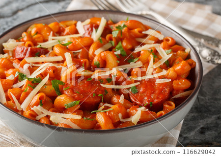 Creamy Gochujang Pasta a fusion of Korean and Italian cuisine with cheddar and parmesan cheese and sausages closeup on the plate. Horizontal 116629042