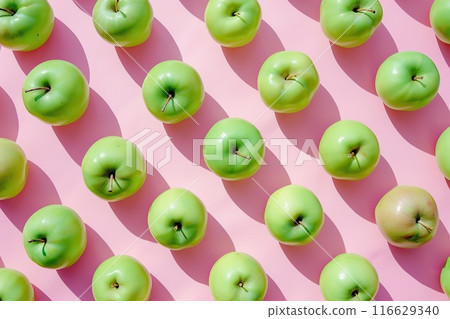 Pattern of ripe green apples on pink background. Arranged fresh whole apples flat lay, top view. Summer natural food, design elements. Lots of raw apples. Tasty and juicy. Minimal trendy fruit concept Pattern of ripe green apples on pink background. Arranged fresh whole apples flat lay, top view. Summer natural food, design elements. Lots of raw apples. Tasty and juicy. Minimal trendy fruit concept 116629340
