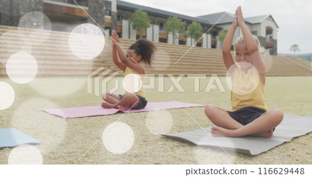 Image of light spots over happy diverse schoolgirls sitting in outdoor yoga class 116629448