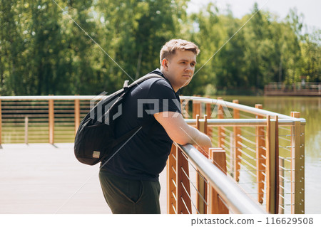 Sad man standing on wooden pier. Thinking about life. Peaceful atmosphere in sunny morning. Spending time alone in nature. Summer time Sad man standing on wooden pier. Thinking about life. Peaceful atmosphere in sunny morning. Spending time alone in nature. Summer time 116629508
