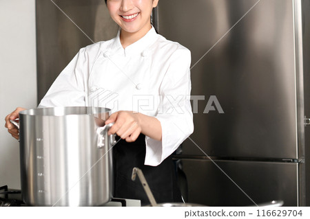 年輕的亞洲女廚師在鍋裡做飯 116629704