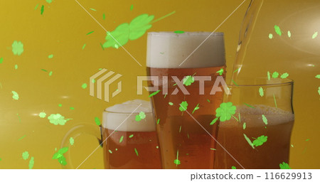 Image of st patrick's day green shamrock falling over beer glasses 116629913