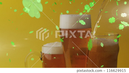 Image of st patrick's day green shamrock falling over beer glasses 116629915