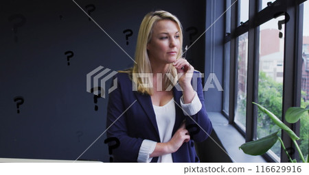 Image of question marks over caucasian businesswoman working at office 116629916