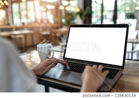 Woman using laptop in office sitting at cafe. Empty blank white screen mockup. Copy space area for text, logo, app. Person working, female hands typing. Mock up display PC. Business websites, service Woman using laptop in office sitting at cafe. Empty blank white screen mockup. Copy space area for text, logo, app. Person working, female hands typing. Mock up display PC. Business websites, service 116630139