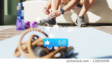 Image of like icon and numbers over african american male athlete tying shoelace 116630496