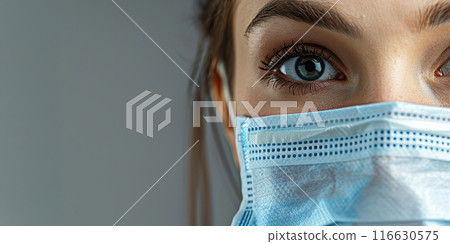 Close up portrait of pretty confident female doctor or scientist wearing medical protective facial mask over grey background. Eye of young woman physician. Medicine, profession and healthcare concept 116630575